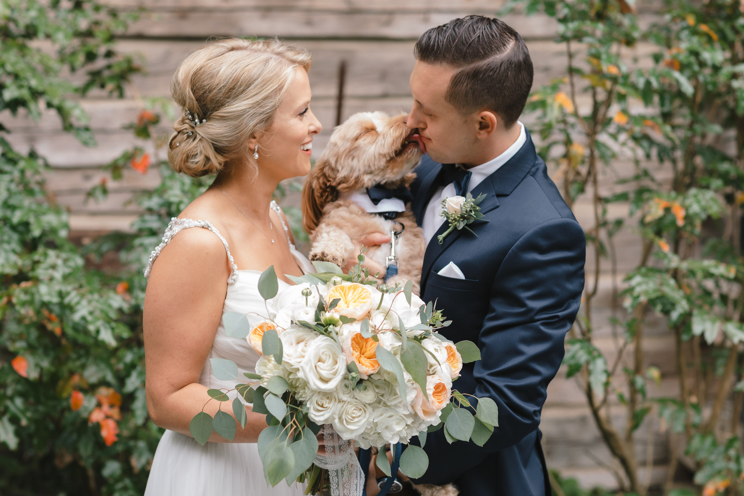 Bride and Groom holding their dog.