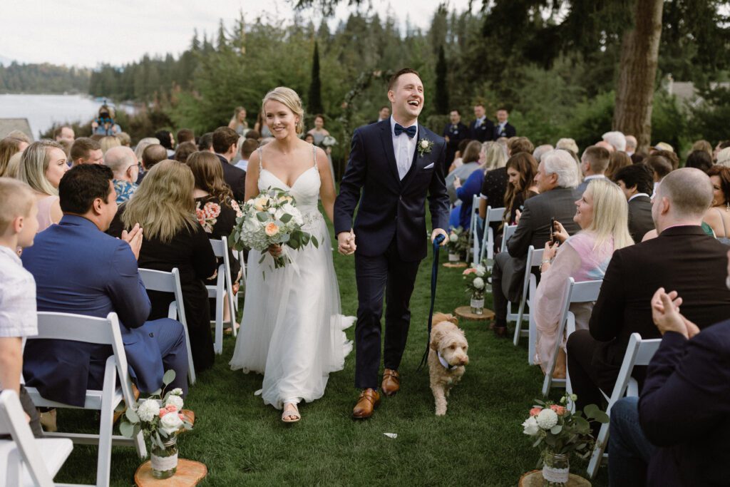 Bride and groom leaving the aisle after the ceremony with their dog.