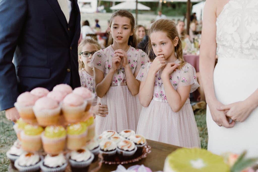 Flower girls looking at delicious deserts. My wedding tip and advice to keep the desert table front and center.