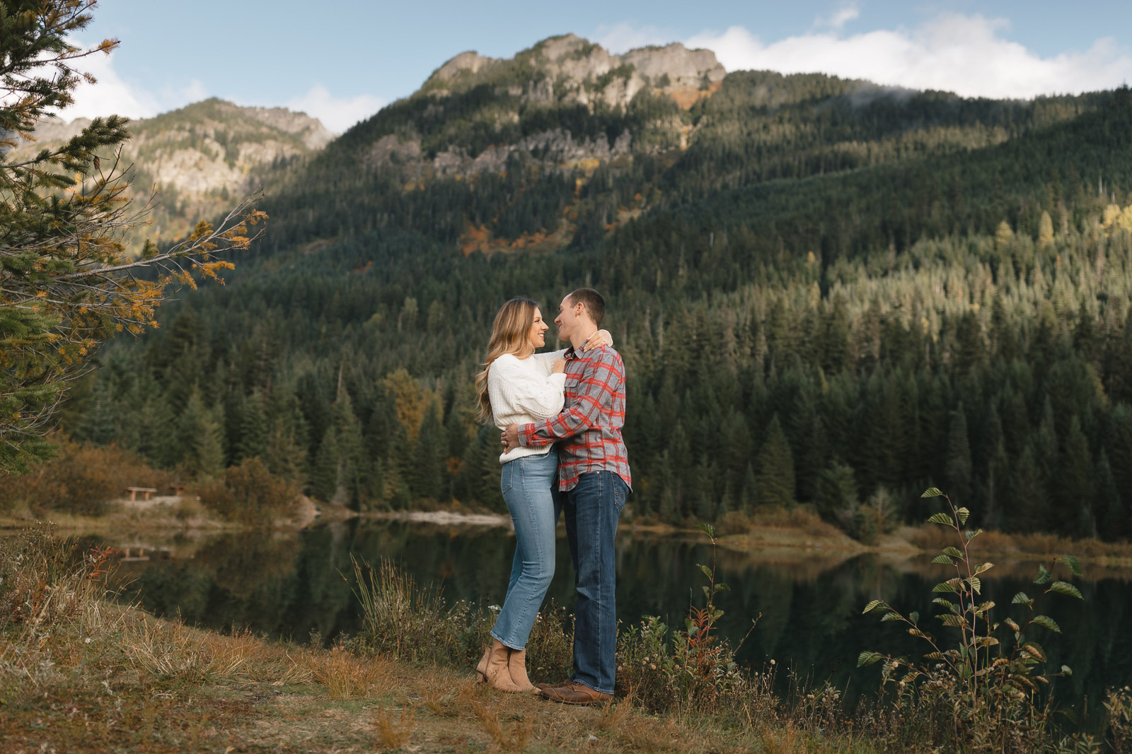 Couple embracing in mountain forest landscape at Gold Creek Pond in Washington State.