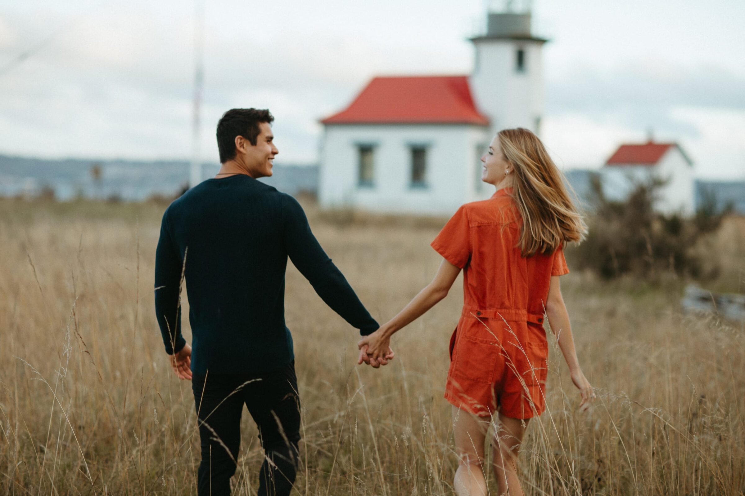 Couple holding hands near lighthouse in field on Vashon Island