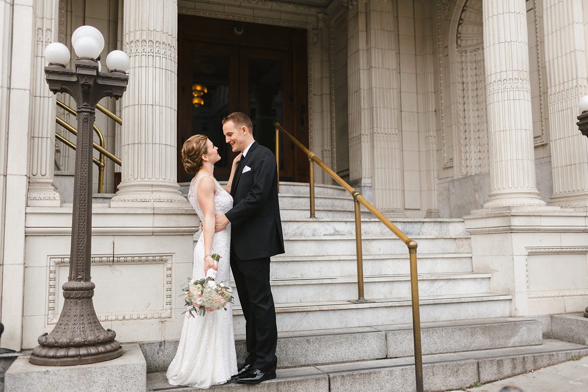 Bride and groom smiling on Arctic Club Hotel steps in Seattle.