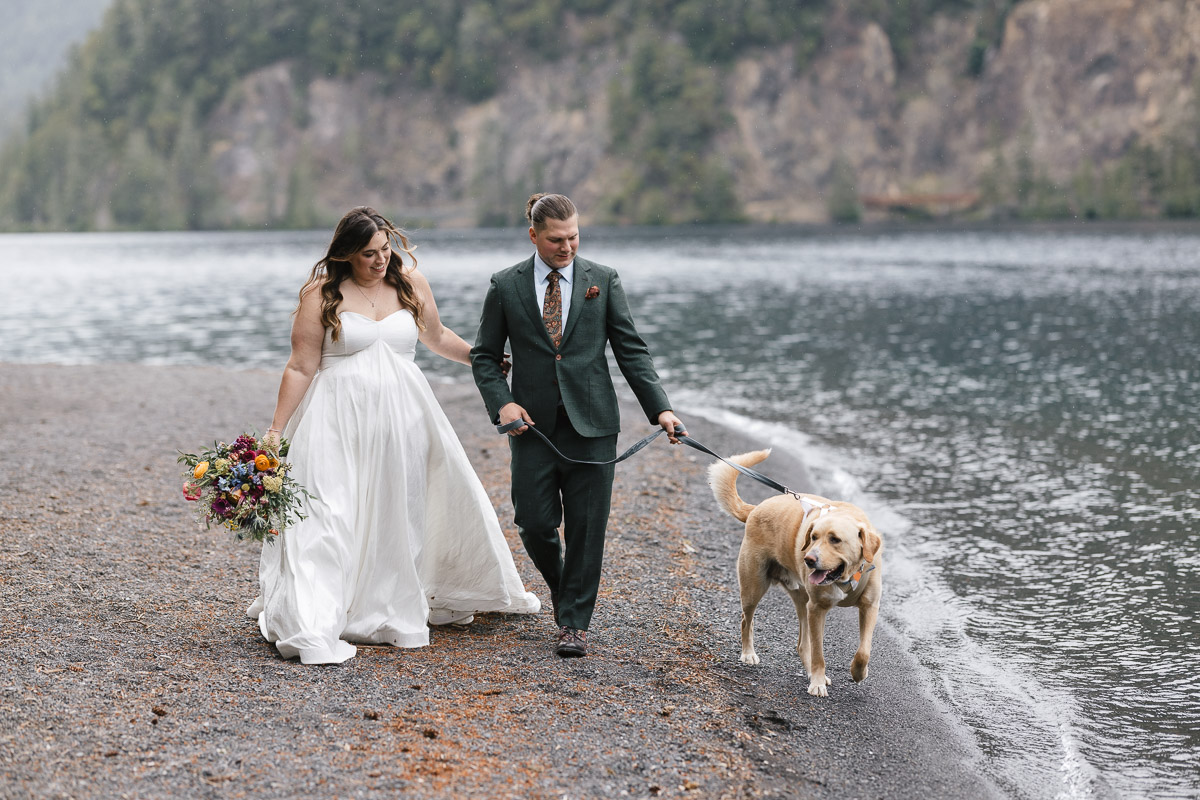 Wedding couple and dog walking by Lake Crescent